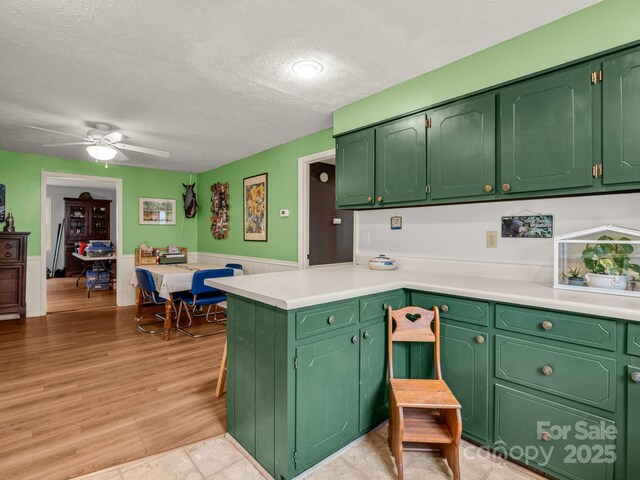 125 Snug Harbor Cir, Lake Lure, NC 28746 - kitchen featuring light countertops, a peninsula, ceiling fan, and a textured ceiling