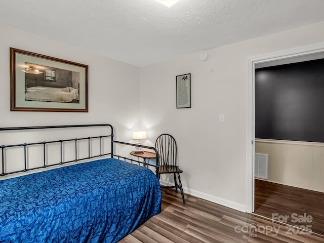 125 Snug Harbor Cir, Lake Lure, NC 28746 - bedroom featuring a textured ceiling, visible vents, wood finished floors, and baseboards
