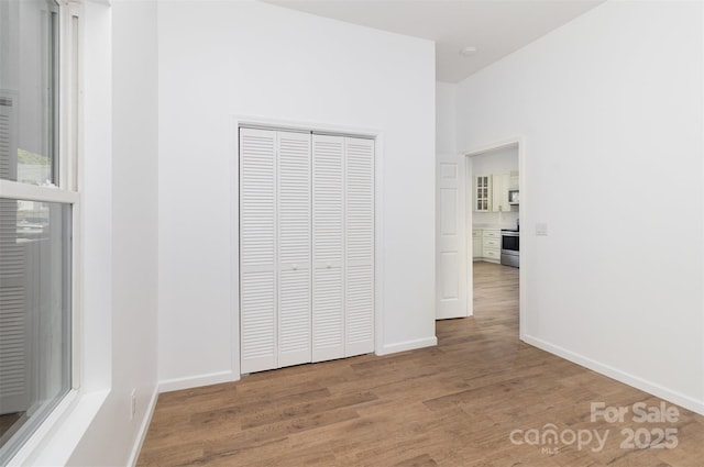555 Pryor St, Chester, SC 29706 - unfurnished bedroom featuring baseboards, a closet, and wood finished floors