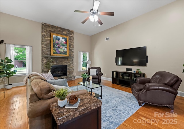 860 Arrow Point Ln, Davidson, NC 28036 - living area featuring a fireplace, light wood-style floors, a ceiling fan, visible vents, and baseboards