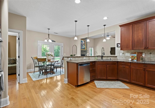 860 Arrow Point Ln, Davidson, NC 28036 - kitchen featuring stainless steel dishwasher, hanging light fixtures, light wood finished floors, a sink, and a peninsula