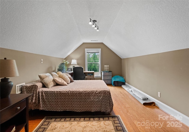 860 Arrow Point Ln, Davidson, NC 28036 - bedroom featuring lofted ceiling, a textured ceiling, visible vents, baseboards, and wood finished floors