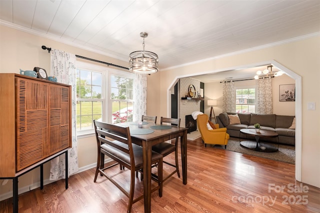 dining area featuring crown molding, a chandelier, and light wood-style floors