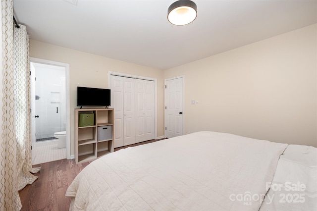 bedroom with a closet, ensuite bath, and wood finished floors
