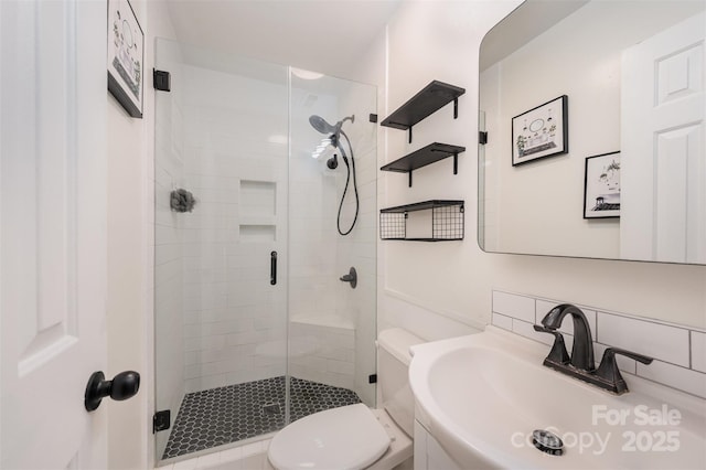 full bathroom featuring toilet, a shower stall, and a sink