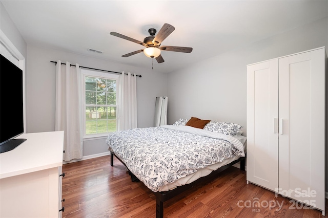 bedroom with visible vents, a ceiling fan, baseboards, and wood finished floors