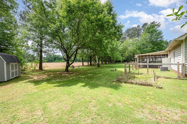 view of yard with a storage shed, cooling unit, an outdoor structure, and a sunroom