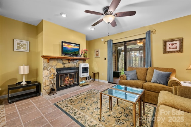 tiled living area with ceiling fan, baseboards, heating unit, and a fireplace