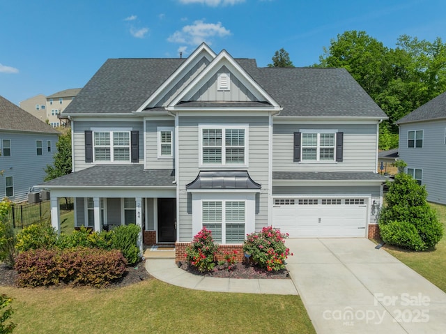 craftsman-style house featuring an attached garage, driveway, a front yard, and a porch