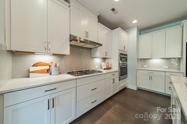 kitchen featuring visible vents, appliances with stainless steel finishes, tasteful backsplash, white cabinets, and under cabinet range hood