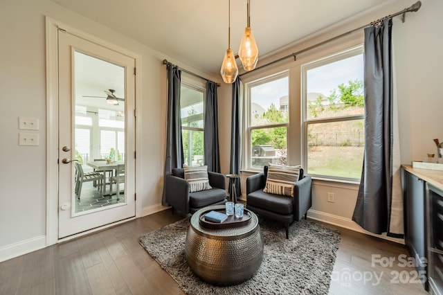 living area with baseboards, wood finished floors, and a wealth of natural light