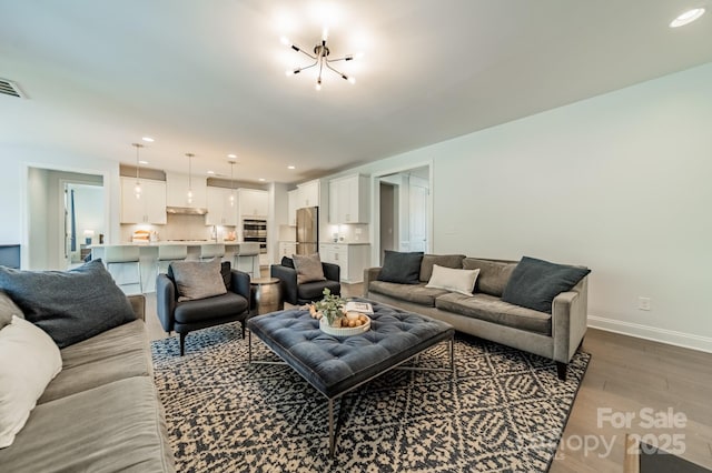 living area with recessed lighting, baseboards, and wood finished floors