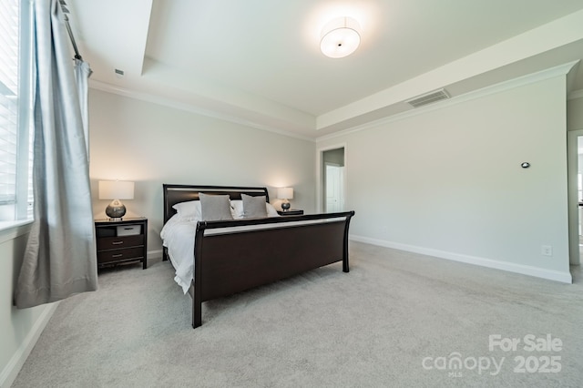 carpeted bedroom with visible vents, a raised ceiling, crown molding, and baseboards