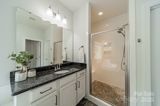 bathroom with visible vents, vanity, and a shower stall