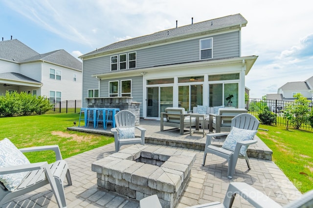 rear view of house featuring a lawn, a patio area, fence, and outdoor dry bar