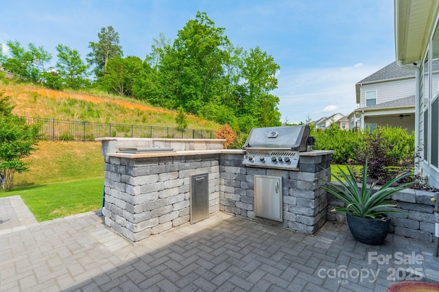 view of patio / terrace featuring area for grilling, exterior kitchen, and fence