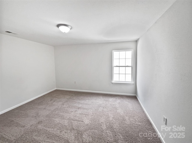 unfurnished room with baseboards, visible vents, and carpet