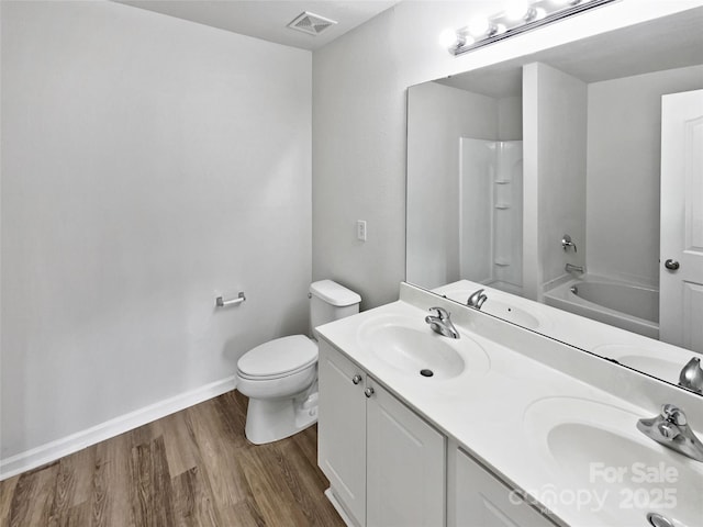 bathroom with wood finished floors, a sink, baseboards, toilet, and visible vents