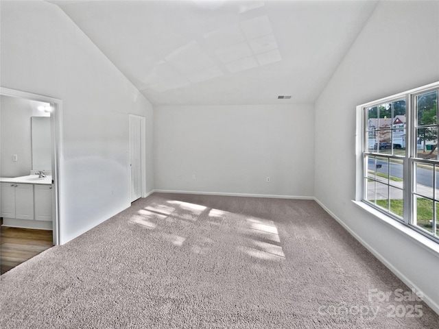 unfurnished room with plenty of natural light, carpet flooring, and high vaulted ceiling