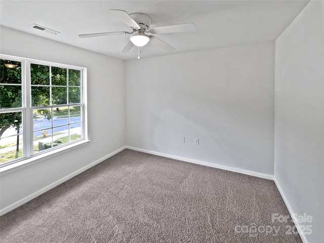 unfurnished room with carpet floors, visible vents, and baseboards