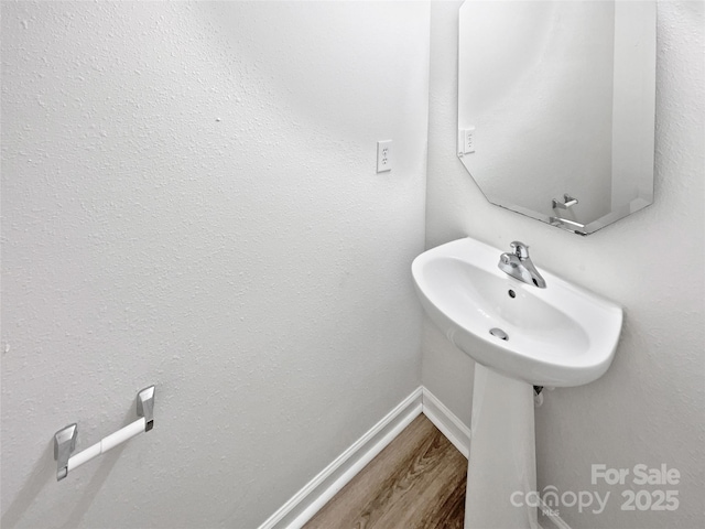 bathroom with baseboards and wood finished floors