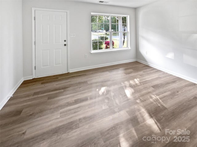 interior space with wood finished floors, visible vents, and baseboards
