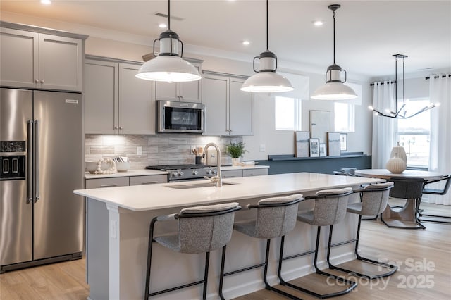 12017 Grinstead Ln Unit 301, Charlotte, NC 28278 - kitchen with stainless steel appliances, a sink, a kitchen island with sink, tasteful backsplash, and light countertops