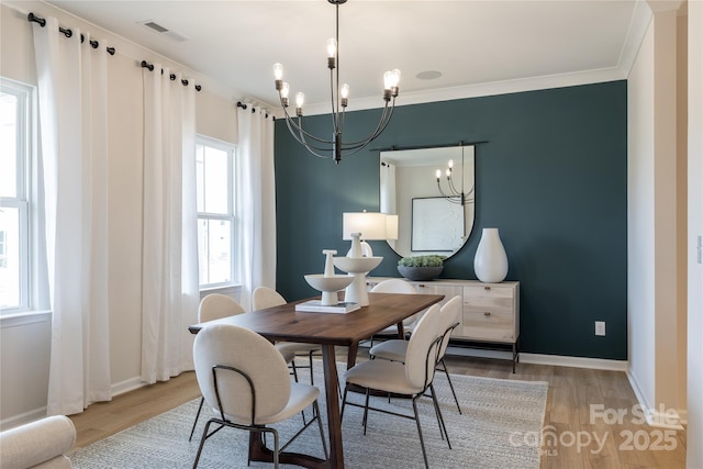 12017 Grinstead Ln Unit 301, Charlotte, NC 28278 - dining room with a chandelier, light wood-style floors, healthy amount of natural light, and ornamental molding