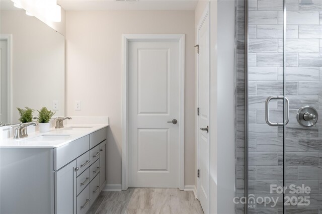 12017 Grinstead Ln Unit 301, Charlotte, NC 28278 - full bathroom featuring a stall shower, marble finish floors, baseboards, and double vanity