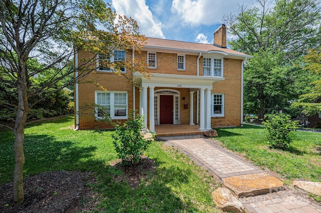 625 2nd St NE, Hickory, NC 28601 - georgian-style home with covered porch, brick siding, a chimney, and a front yard