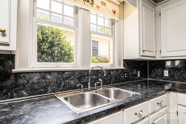 625 2nd St NE, Hickory, NC 28601 - kitchen with a sink, white cabinetry, dark countertops, and backsplash