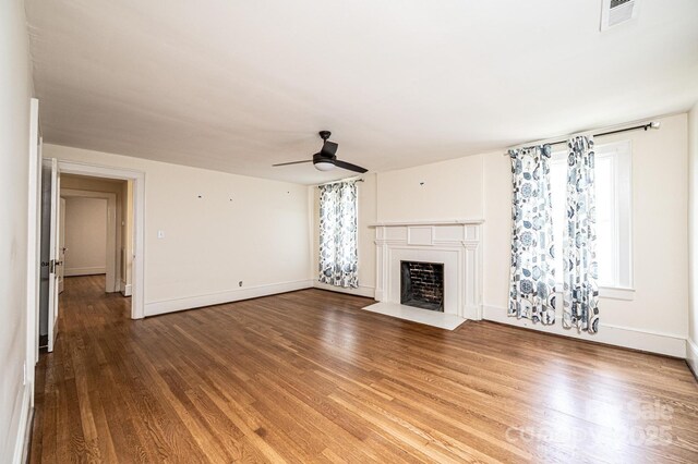 625 2nd St NE, Hickory, NC 28601 - unfurnished living room with a ceiling fan, a fireplace with flush hearth, wood finished floors, and plenty of natural light