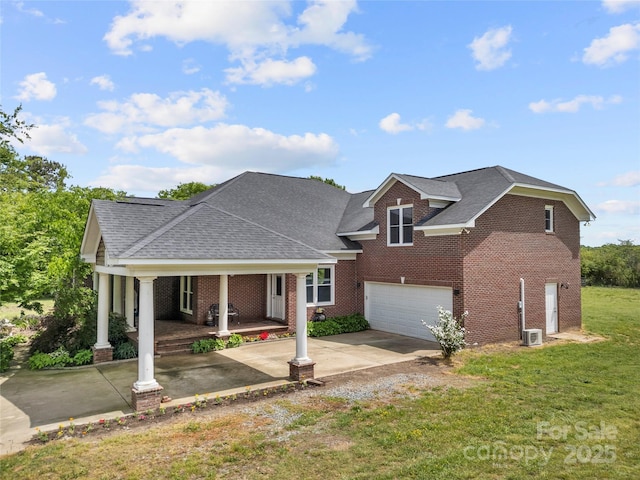 traditional home with a porch, concrete driveway, brick siding, and a garage