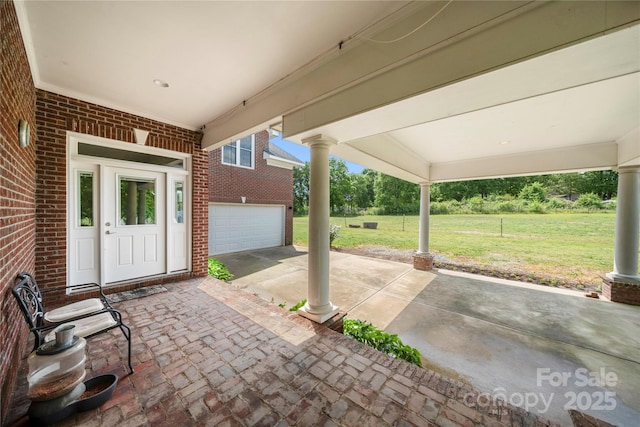 view of patio with a garage and concrete driveway