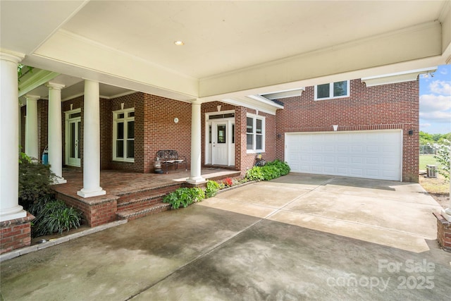 view of patio with covered porch, concrete driveway, and a garage
