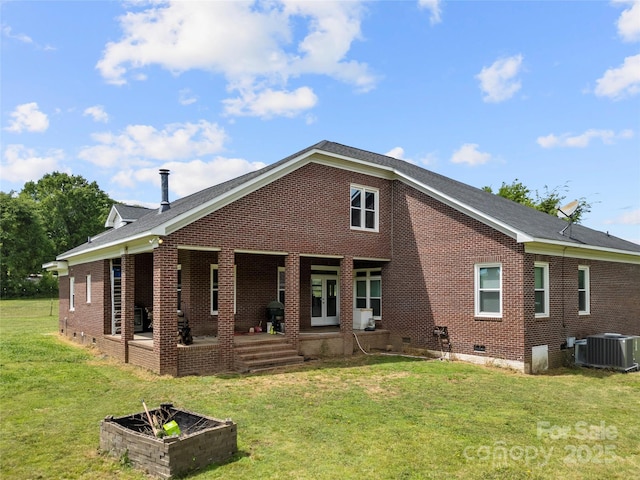 rear view of property featuring brick siding, crawl space, a lawn, central AC, and a patio area