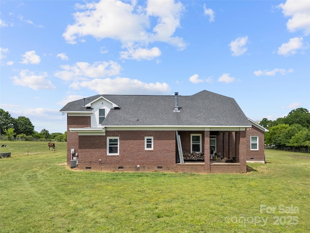 back of property with crawl space, a lawn, brick siding, and a shingled roof