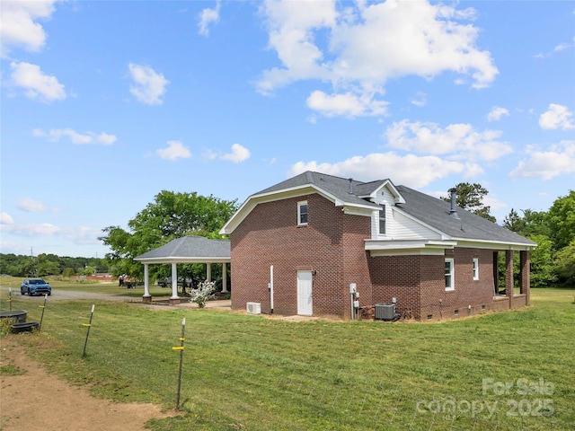 view of property exterior with a gazebo, central AC, a yard, brick siding, and crawl space