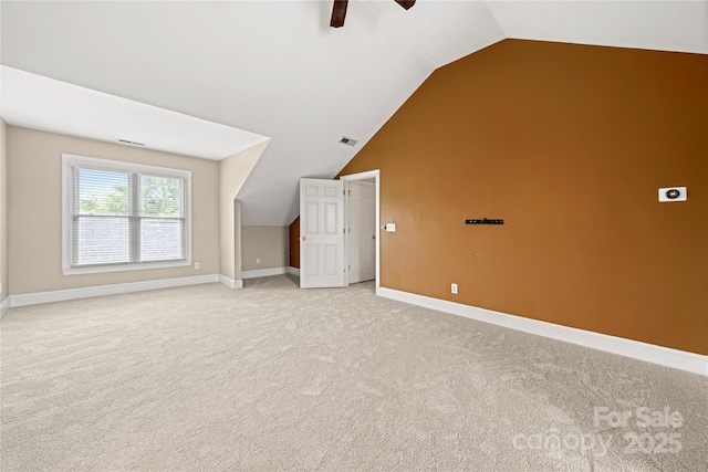 additional living space featuring ceiling fan, vaulted ceiling, light colored carpet, and baseboards