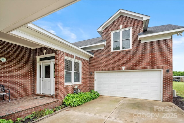 view of front of property featuring brick siding, concrete driveway, and a garage