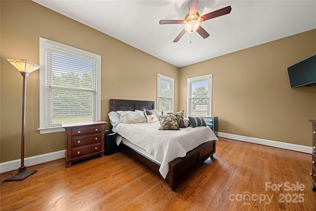 bedroom with baseboards, light wood finished floors, and ceiling fan