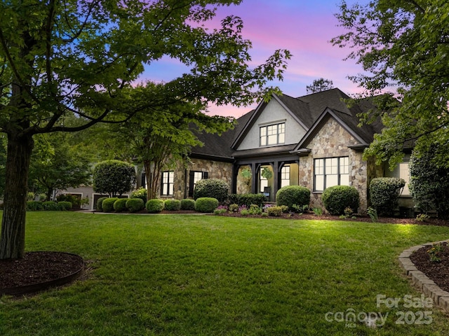 view of front of property with a front yard and stone siding