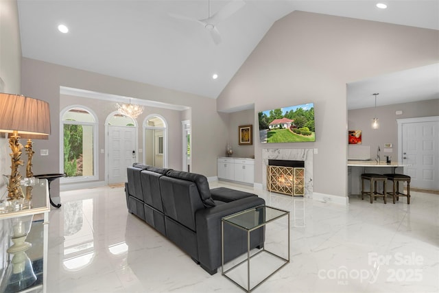 living room with light marble finish floors, a fireplace, recessed lighting, high vaulted ceiling, and a ceiling fan