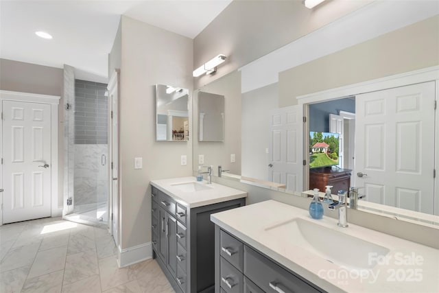 full bathroom with a shower stall, marble finish floors, two vanities, baseboards, and recessed lighting