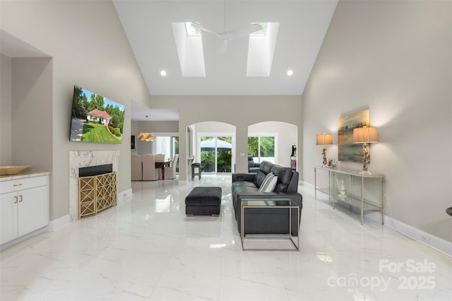 1004 Berwick Ct, Waxhaw, NC 28173 - living area with high vaulted ceiling, light marble finish flooring, baseboards, a skylight, and recessed lighting
