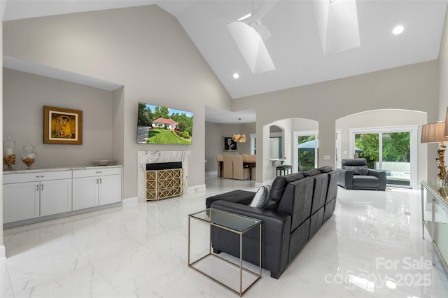 1004 Berwick Ct, Waxhaw, NC 28173 - living area with arched walkways, high vaulted ceiling, light marble finish flooring, a skylight, and recessed lighting