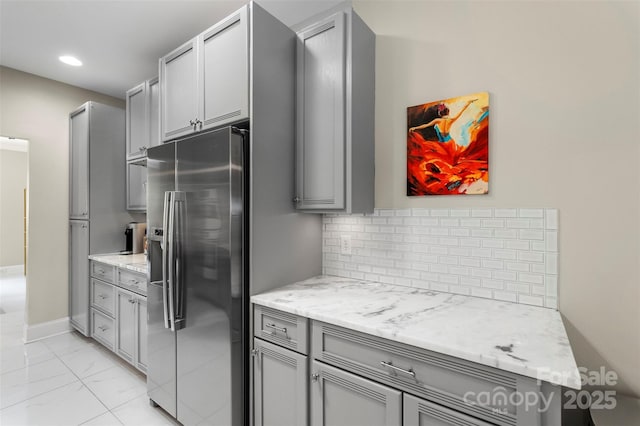 1004 Berwick Ct, Waxhaw, NC 28173 - kitchen featuring stainless steel fridge, gray cabinetry, light marble finish floors, decorative backsplash, and recessed lighting
