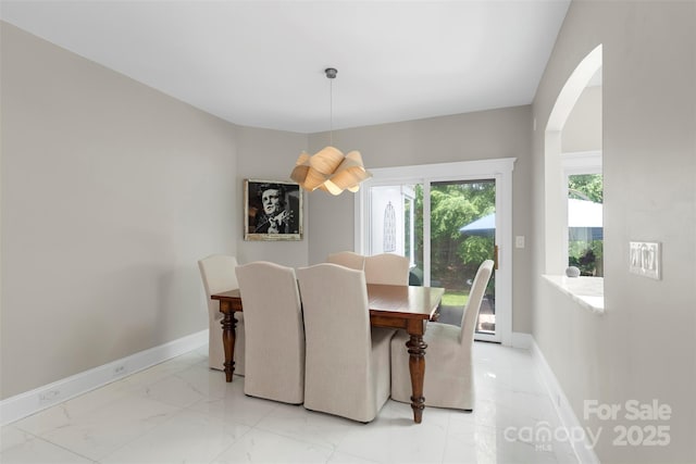 1004 Berwick Ct, Waxhaw, NC 28173 - dining area featuring arched walkways, light marble finish floors, and baseboards