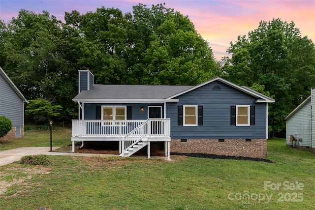 ranch-style house with roof with shingles, a porch, a chimney, a lawn, and crawl space