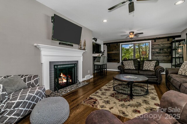 living room with a ceiling fan, recessed lighting, and wood finished floors